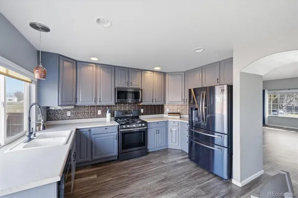 a kitchen with stainless steel appliances a refrigerator sink and stove