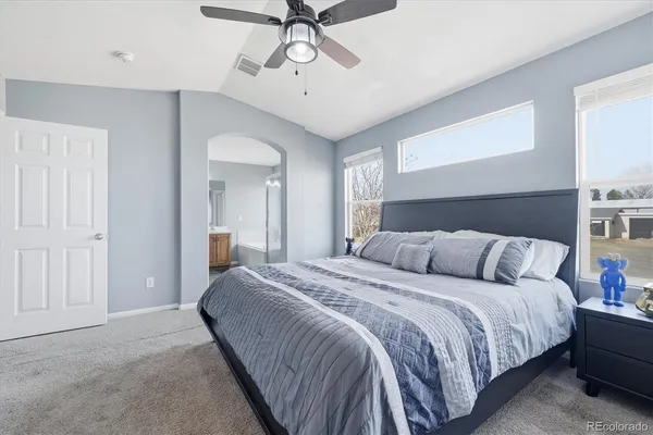a bedroom with a large bed and ceiling fan