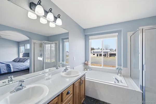 a bathroom with a tub double sink and mirror