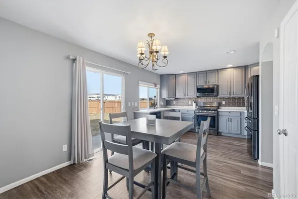 a kitchen with a dining table chairs refrigerator and cabinets