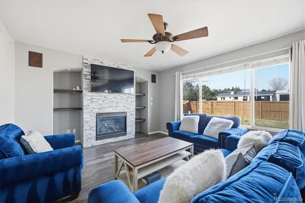 a living room with furniture a flat screen tv and a fireplace