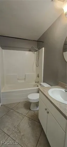 a bathroom with a granite countertop sink a toilet and shower