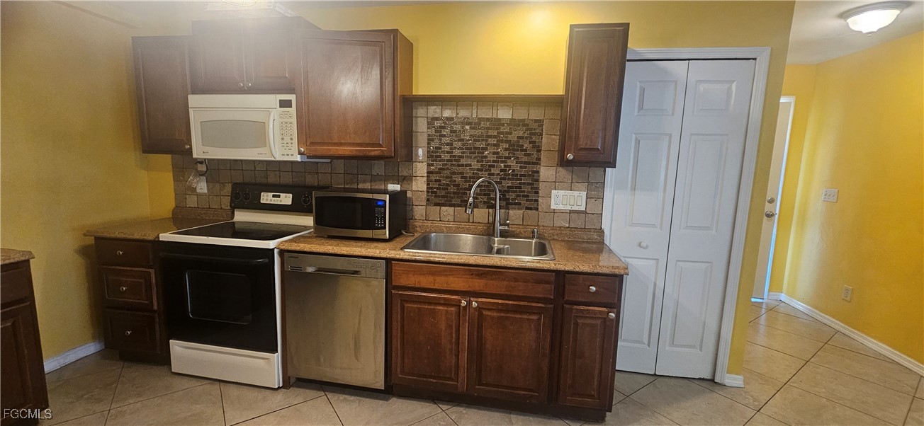 4722 30th Street Southwest Lehigh Acres, FL 33973 - Photo 2 of 12 a kitchen with a stove and a microwave