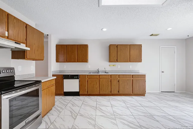 a kitchen with stainless steel appliances granite countertop a stove a sink and a microwave