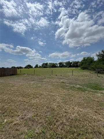 a view of a lake in middle of a field