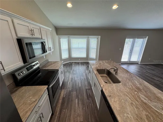 a bedroom with wooden floor and window