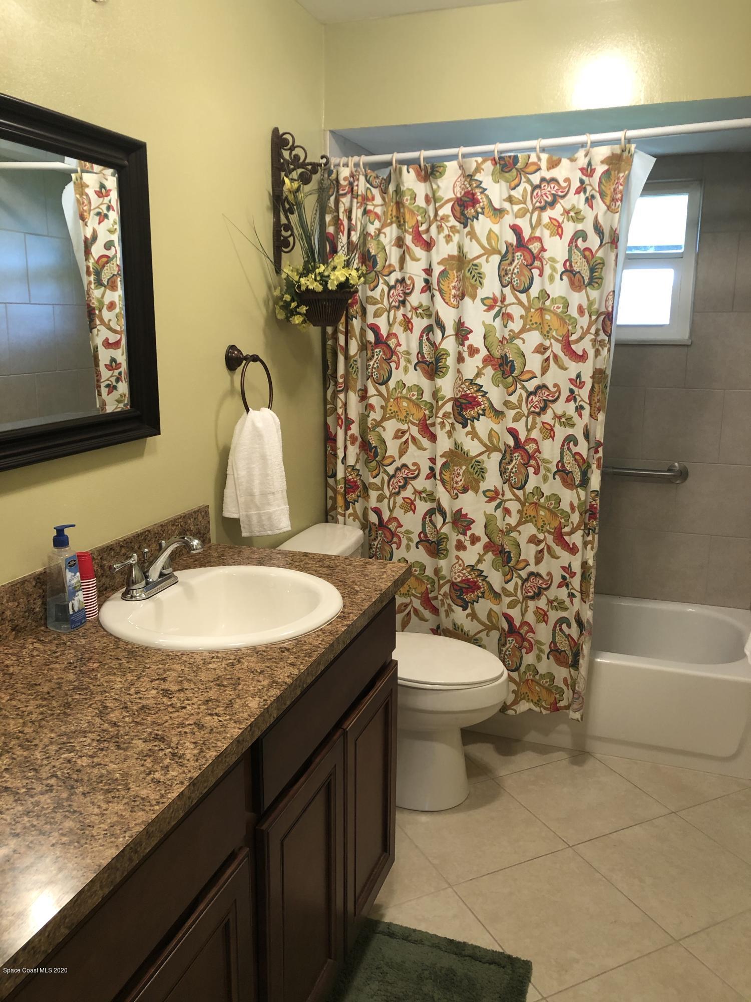 1491 Creel Road Northeast Palm Bay, FL 32905 - Photo 5 of 50 a bathroom with a granite countertop sink and a mirror