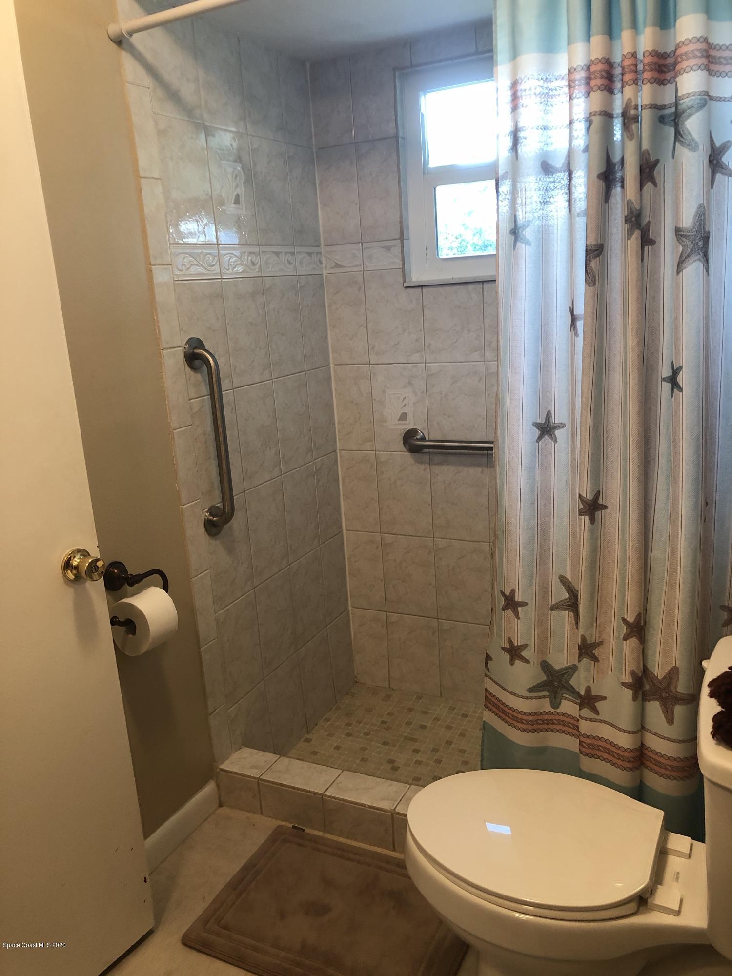 1491 Creel Road Northeast Palm Bay, FL 32905 - Photo 8 of 50 a bathroom with a sink toilet and shower