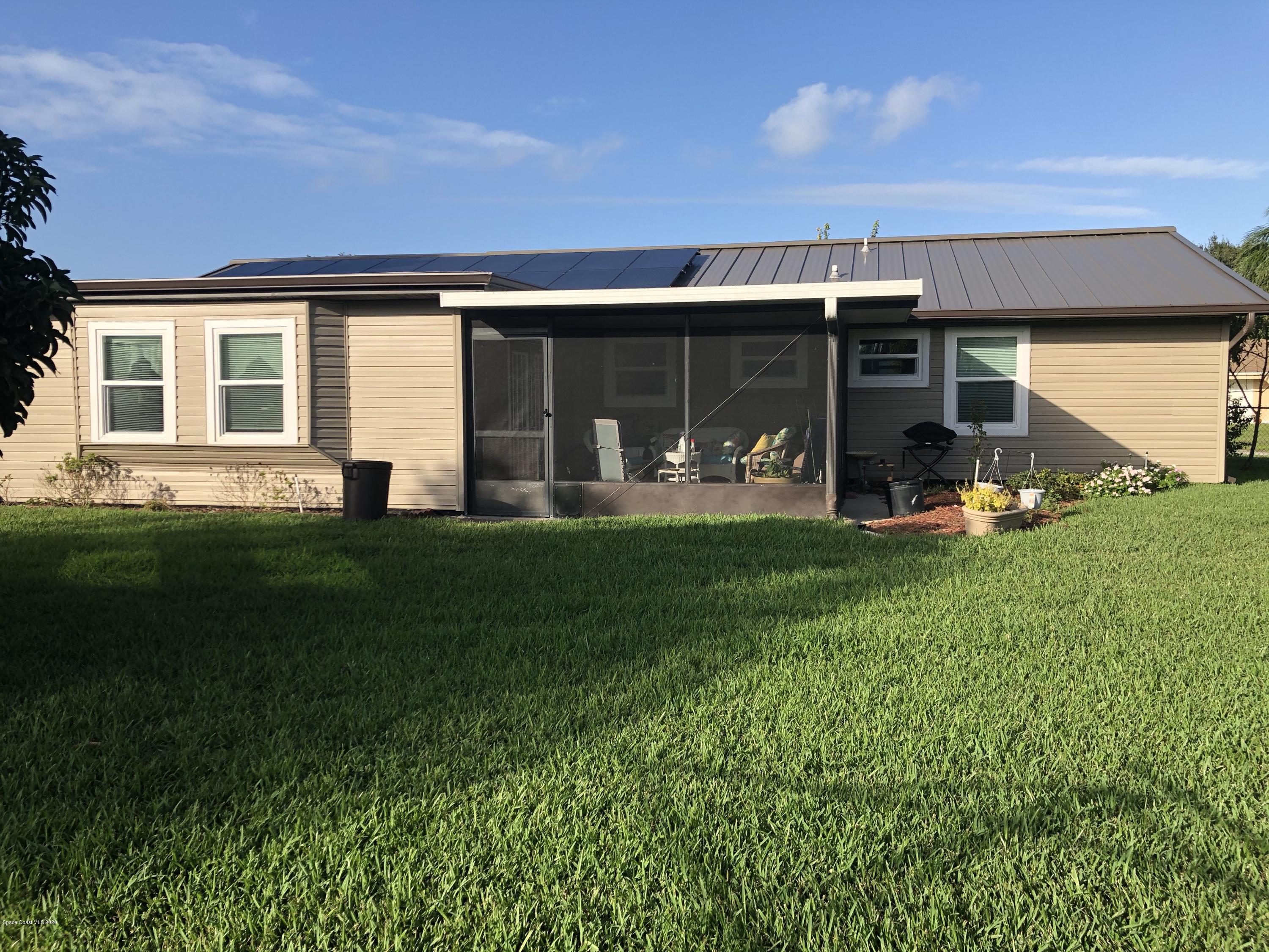 1491 Creel Road Northeast Palm Bay, FL 32905 - Photo 9 of 50 a front view of a house with a yard and sitting area