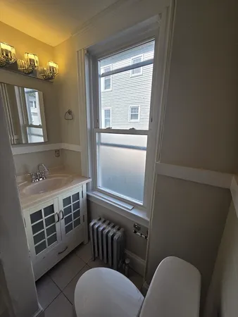 a bathroom with a sink mirror vanity and toilet
