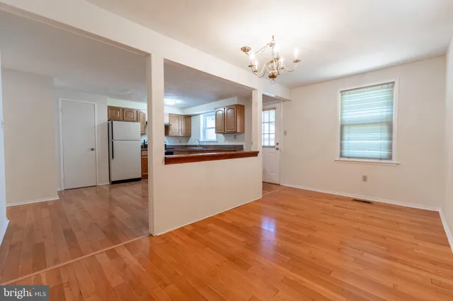 a view of a room with wooden floor and chandelier
