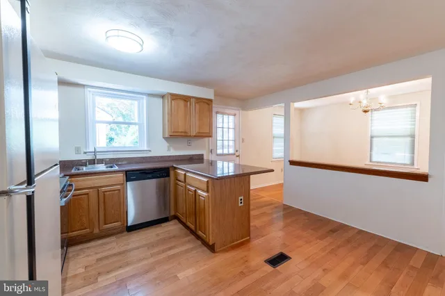 a kitchen with stainless steel appliances granite countertop a stove a sink and a window