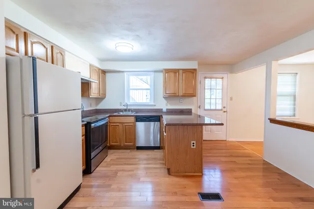 a kitchen with a refrigerator sink and wooden floor