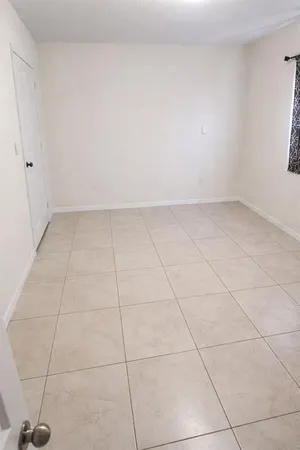 an empty room with a window and a fan