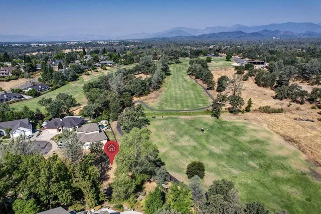 an aerial view of residential houses with outdoor space and trees