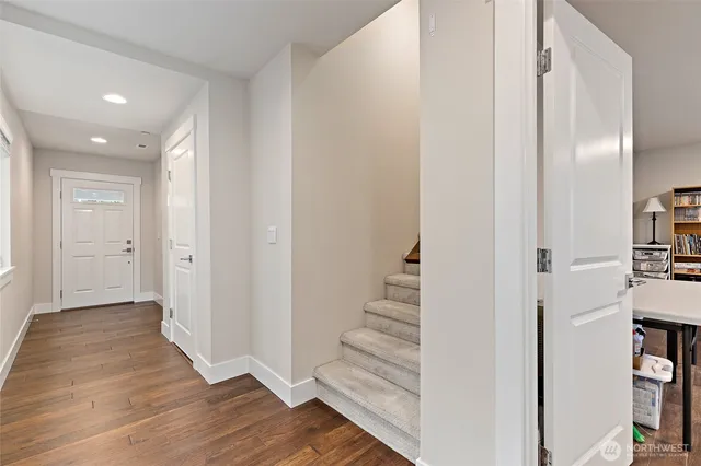 a view of a hallway with wooden floor and entryway