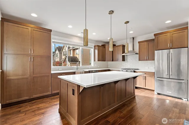 a kitchen with kitchen island a sink appliances and wooden floor