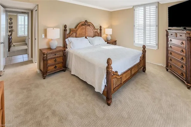 a bedroom with a bed and a flat tv screen on wall