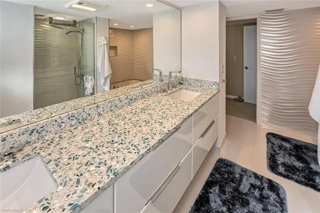 a bathroom with a granite countertop sink and a bathtub