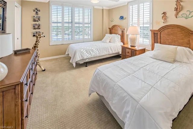 a bedroom with two beds and a window