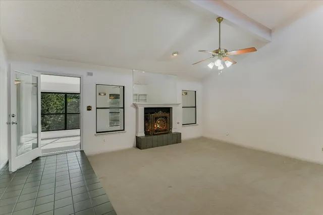 an empty room with fireplace and windows