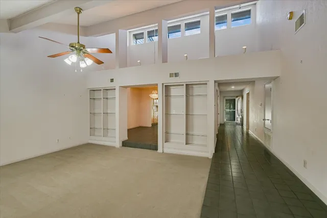 a view of an empty room with window and cabinet