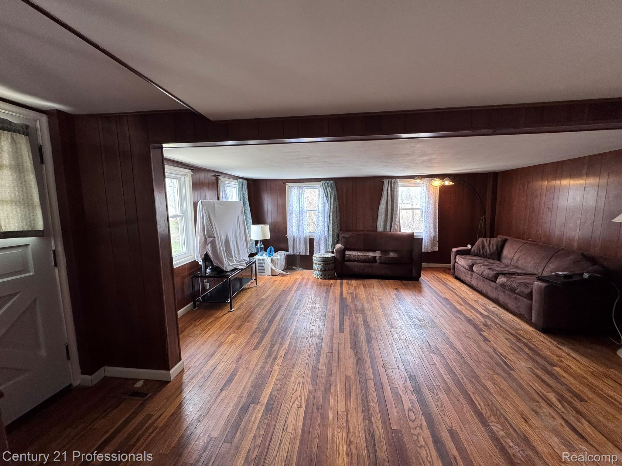 2021 West Rose Center Road Holly, MI 48442 - Photo 27 of 30 Living room with wood walls and dark wood finished floors