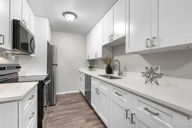 a kitchen with a sink and white cabinets