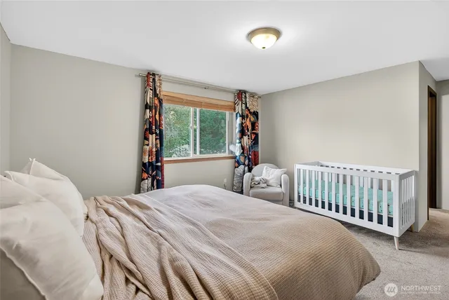 a bedroom with a bed and a large window