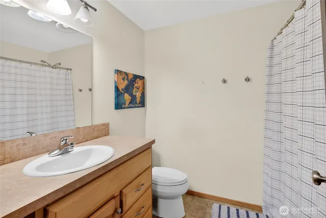 a bathroom with a sink vanity mirror and toilet