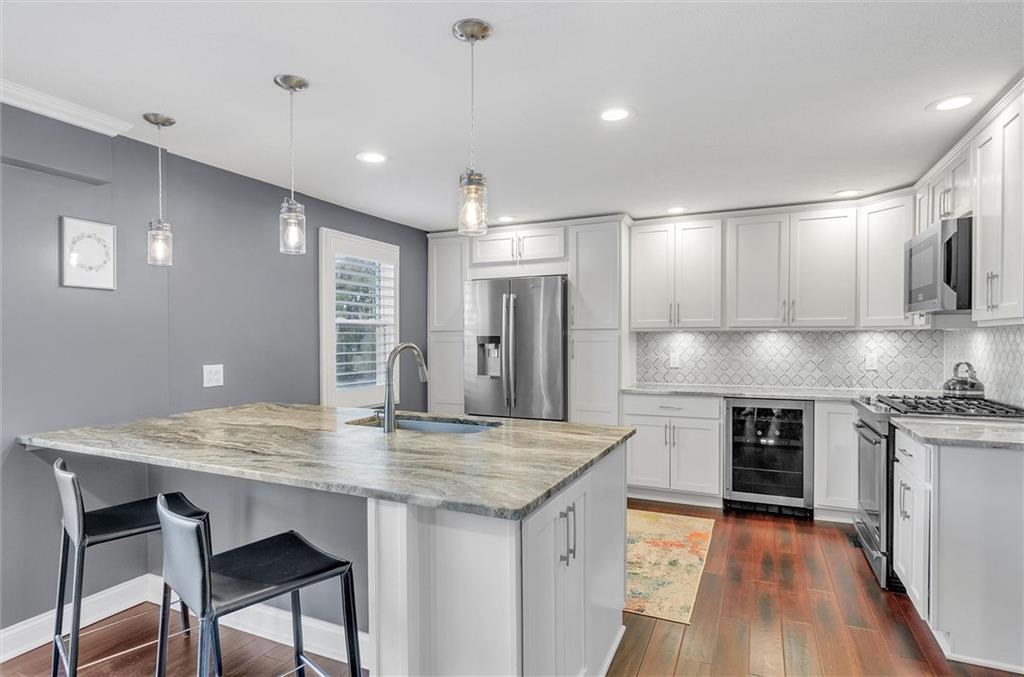 2389 Mill Grove Road Pittsburgh, PA 15241 - Photo 11 of 25 a kitchen with stainless steel appliances granite countertop a kitchen island hardwood floor sink and stove