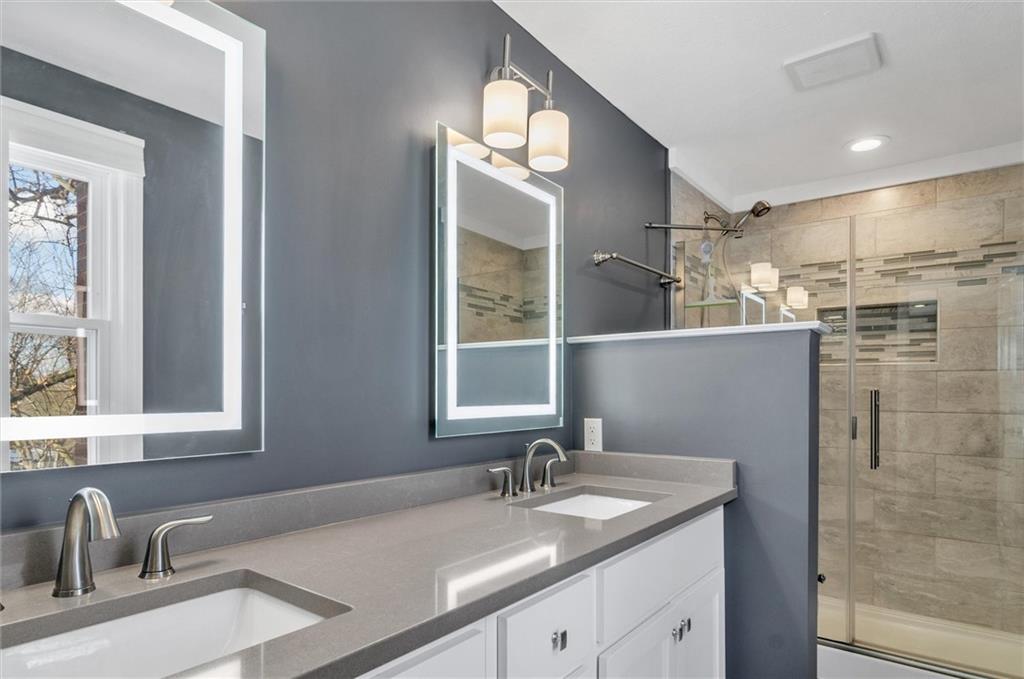 2389 Mill Grove Road Pittsburgh, PA 15241 - Photo 14 of 25 a bathroom with a granite countertop sink a large mirror and a shower