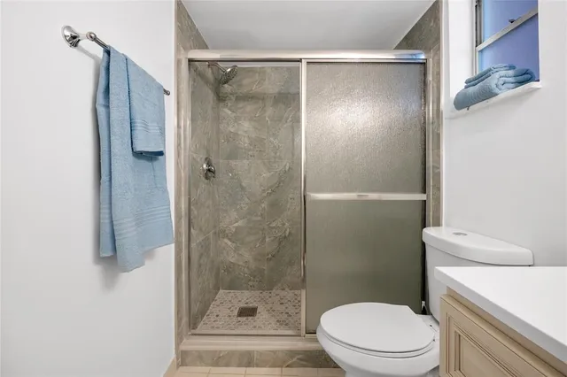 a bathroom with a shower a toilet and a sink