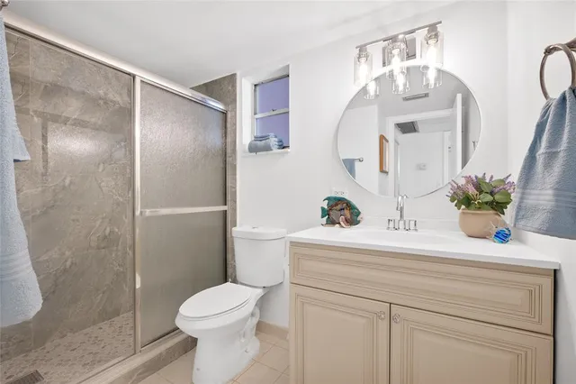 a bathroom with a sink a mirror a toilet and shower