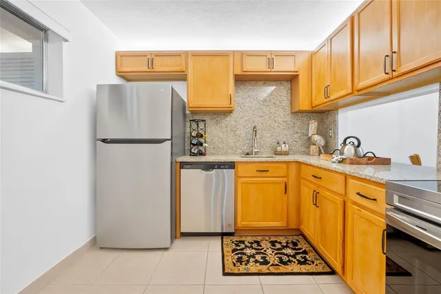 a kitchen with sink a refrigerator and a stove top oven