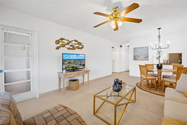 a living room with furniture a rug and a chandelier fan