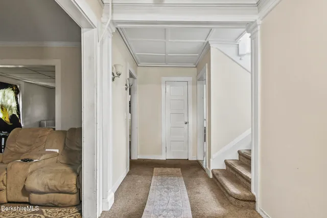 a view of a hallway with wooden floor and staircase