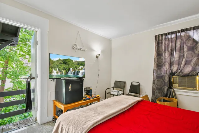 a bedroom with a bed a window and a fireplace