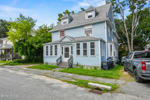 a front view of a house with a yard and a garage