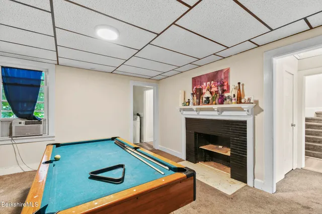 a living room with furniture pool table and a fireplace