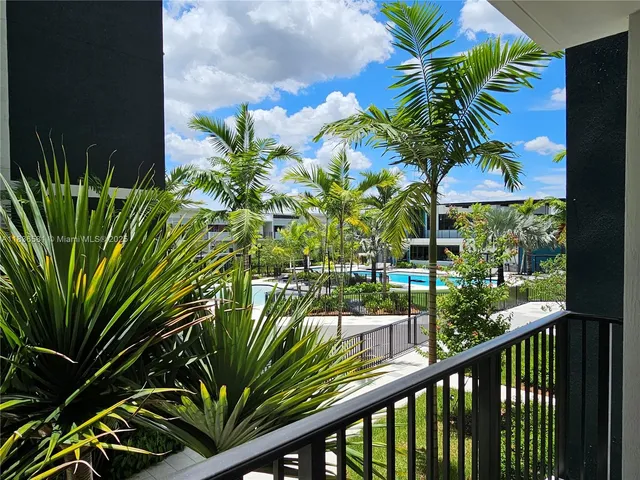 a view of a swimming pool with a garden and trees