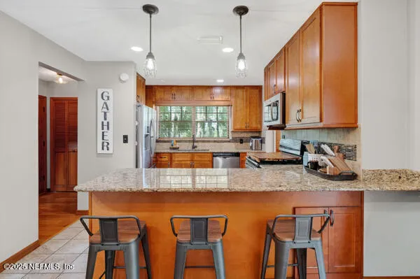 a kitchen with stainless steel appliances granite countertop a stove a sink and a microwave