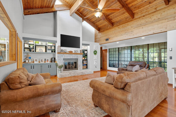 6519 Neale Road Melrose, FL 32666 - Photo 25 of 57 a living room with furniture a flat screen tv and a floor to ceiling window