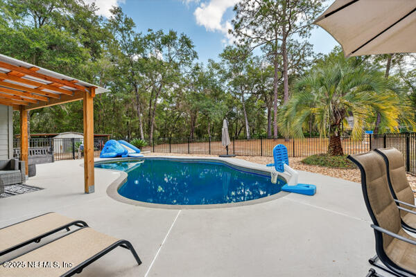 6519 Neale Road Melrose, FL 32666 - Photo 47 of 57 a view of a swimming pool with a patio and a garden