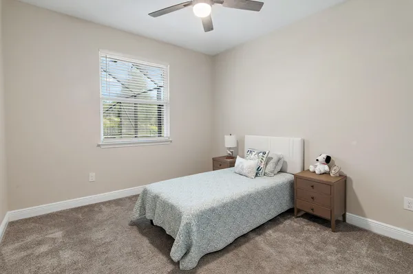 an empty room with a window and a chandelier fan