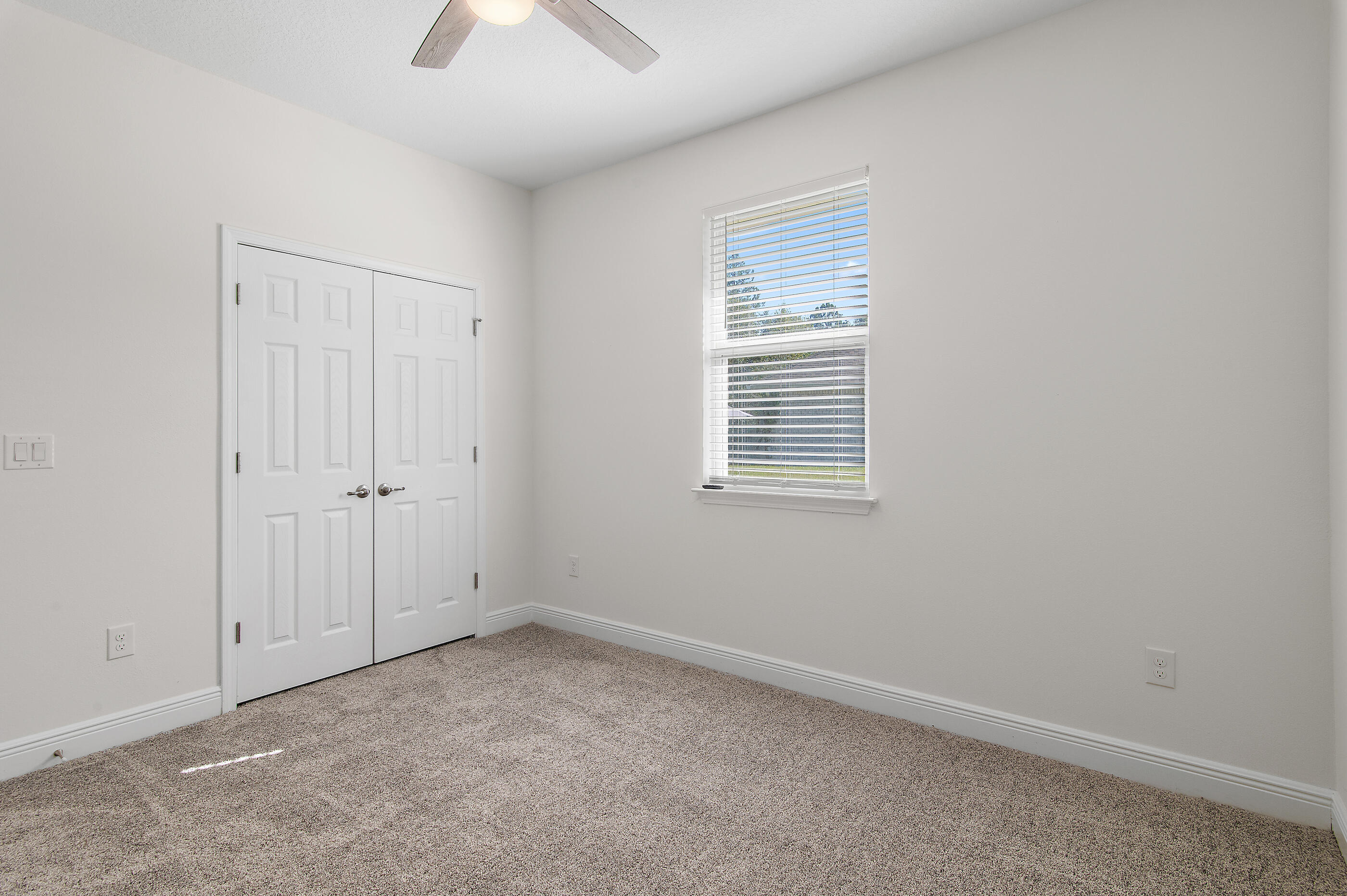 588 Windswept Boulevard Freeport, FL 32439 - Photo 31 of 62 an empty room with a window and a chandelier fan