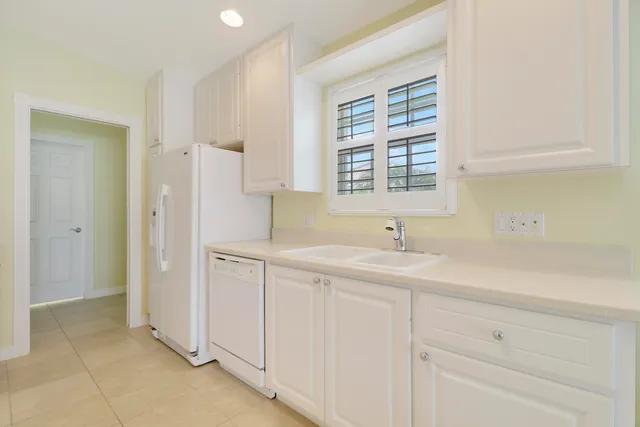 a kitchen with white cabinets and a sink