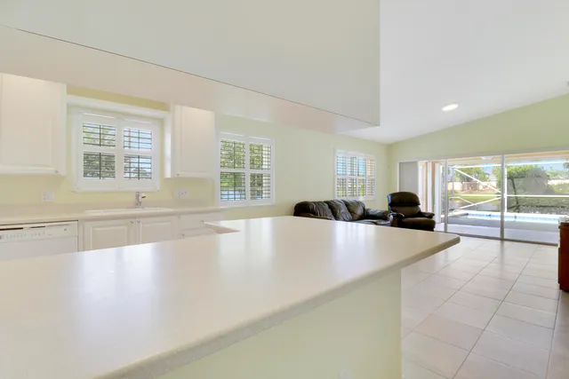 a large white kitchen with a large window