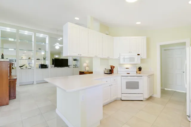 a kitchen with a sink a stove a refrigerator and white cabinets