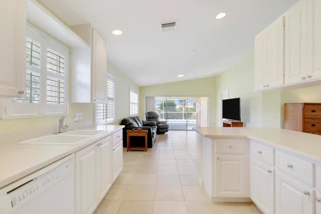a large white kitchen with a large window